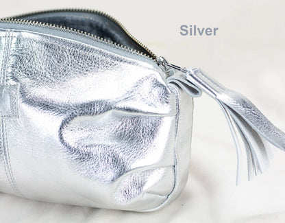 Silver clutch bag with a tassel on a light background