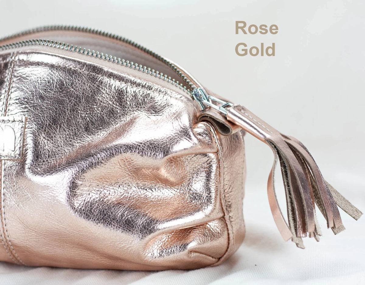 Rose gold pouch with tassel on a light background