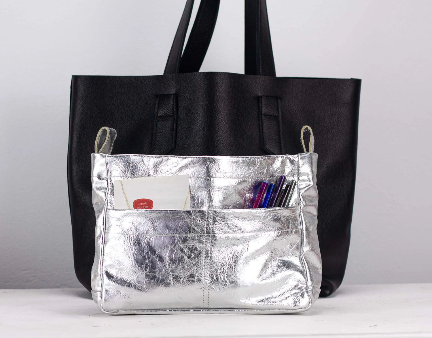 Silver bag insert with a silver pocket on a light gray background
