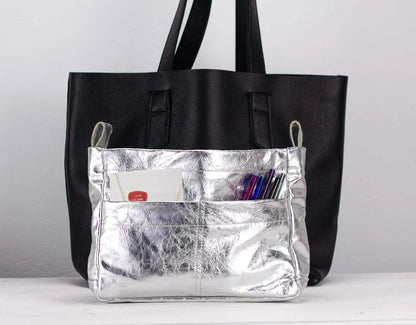 Silver bag insert with a silver pocket on a light gray background