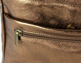 Close-up of a bronze leather bag with a zipper