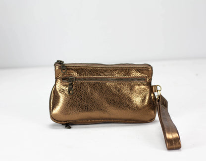 Brass metallic handbag with a strap on a white background