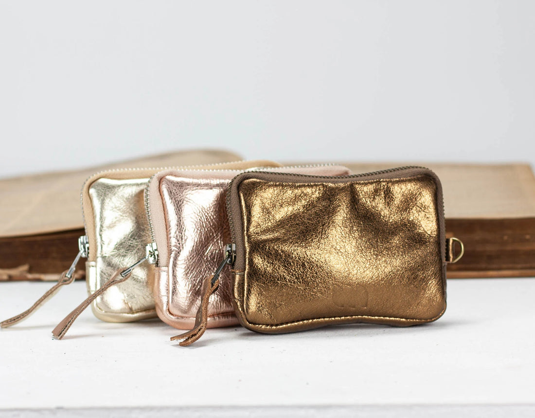 Gold metallic pouches on a white background
