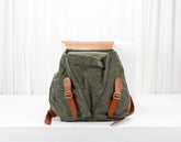 Green backpack with brown straps on a white background