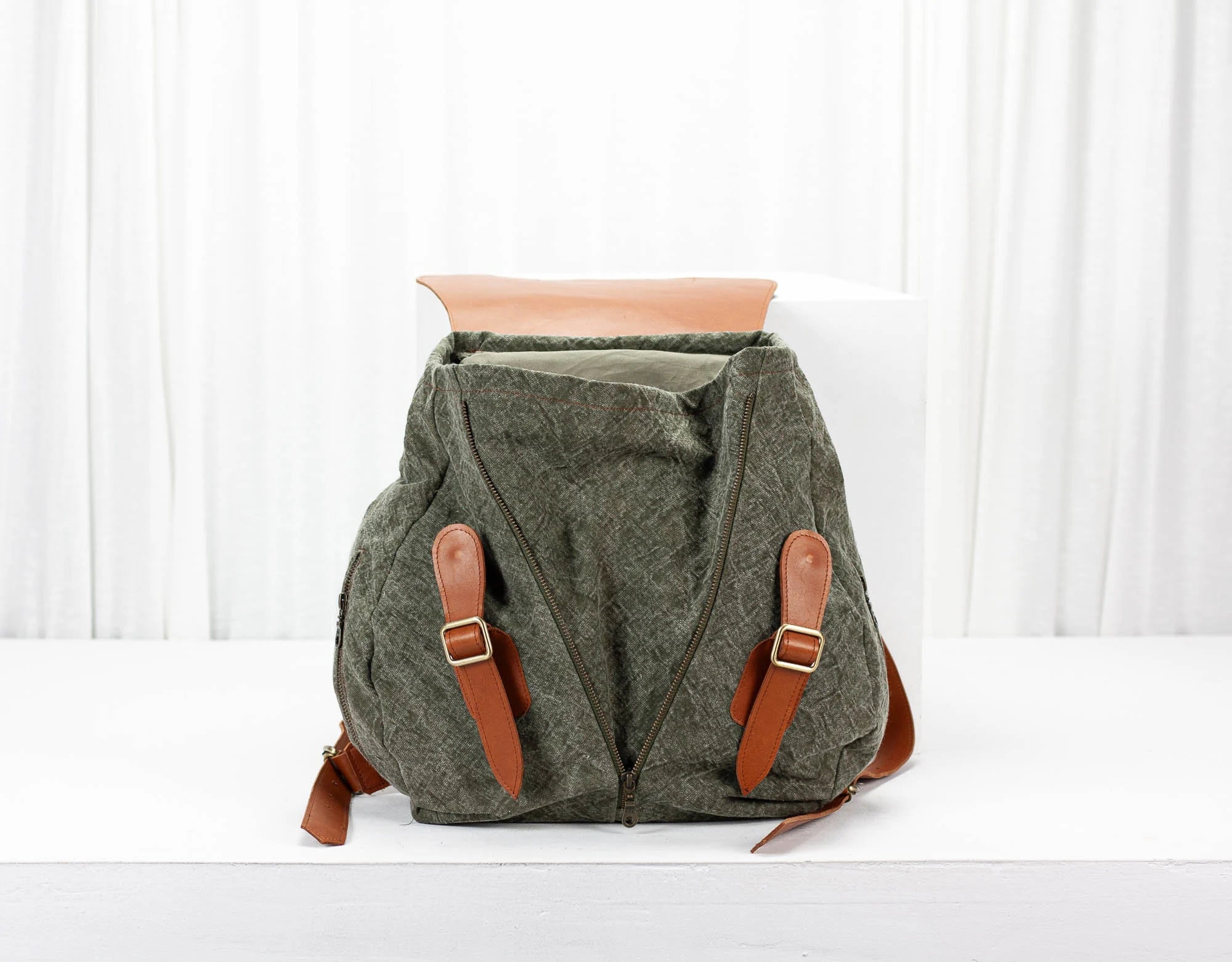 Green backpack with brown straps on a white background