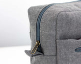 Close-up of a gray textured bag with a zipper on a white background