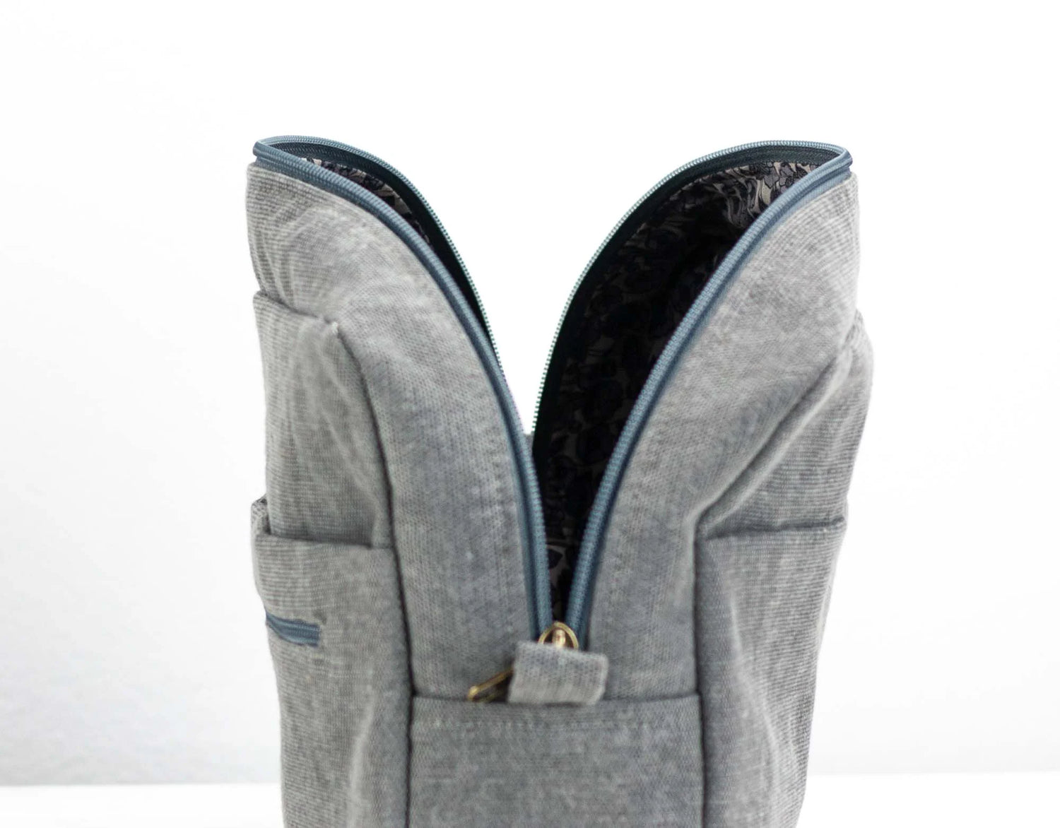 Gray backpack with blue zipper on a white background