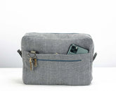 Gray fabric bag with a pocket and key holder on a white background