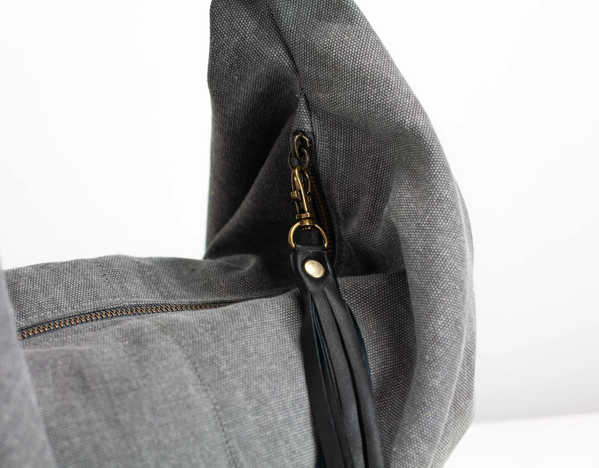 Gray bag with a zipper and gold clasp on a white background