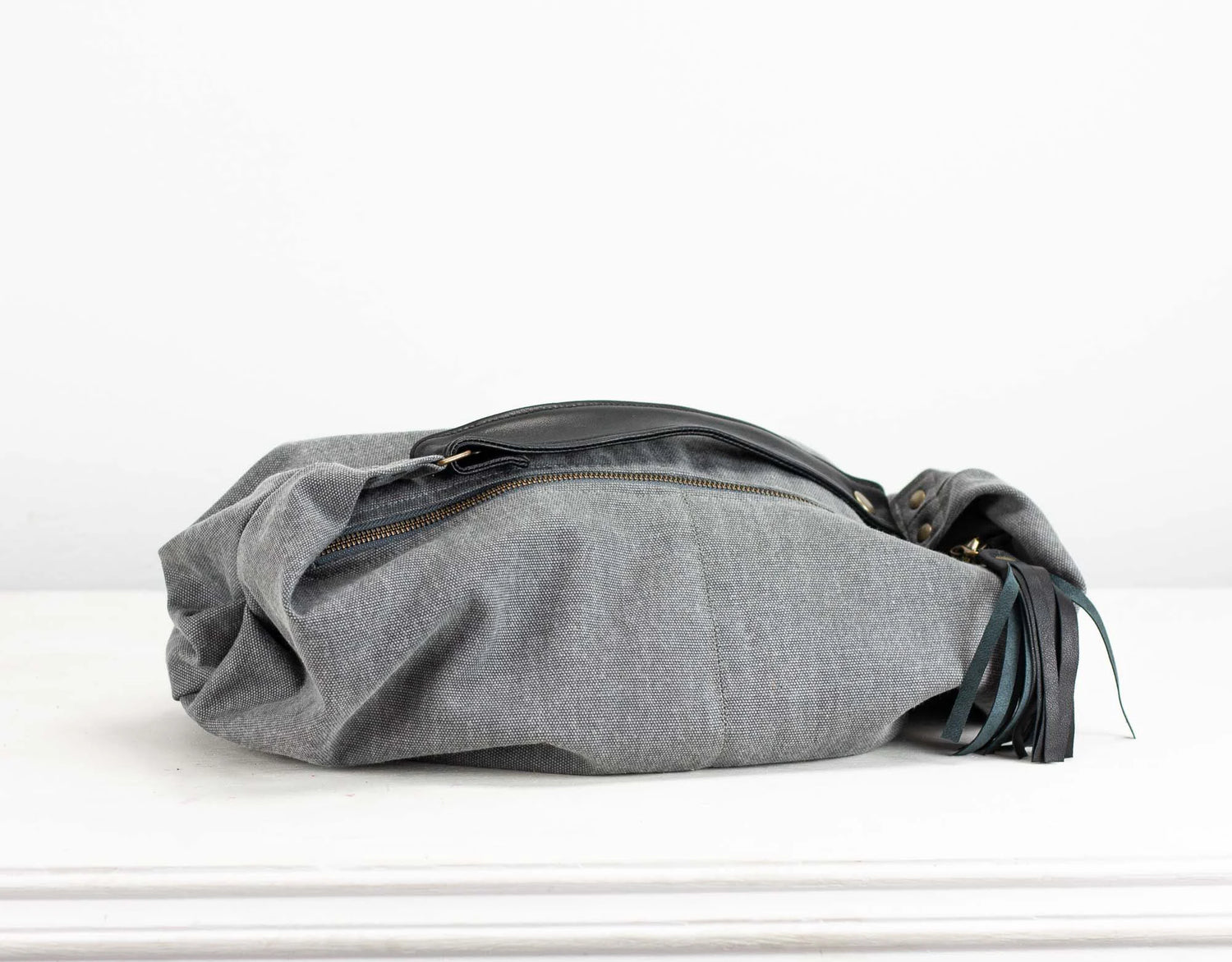 Gray fabric bag with black accents on a white background