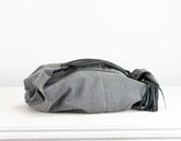 Gray fabric bag with black accents on a white background