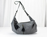 Gray shoulder bag with black tassels on a white background
