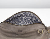 Gray leather bag with floral lining on a white background