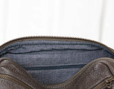 Grey leather bag with blue interior lining on a white background