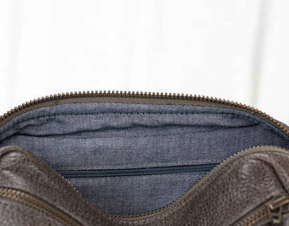 Brown leather bag with blue interior lining on a white background
