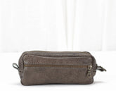 Brown leather toiletry bag with a zipper on a white background