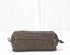 Brown leather toiletry bag with a zipper on a white background
