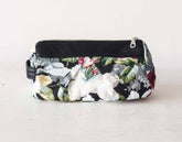 Floral-patterned pouch with a black zipper on a light gray background