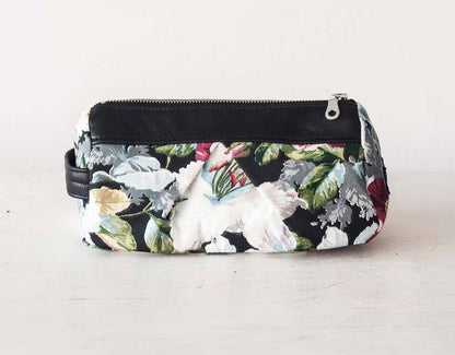 Floral-patterned pouch with a black zipper on a light gray background