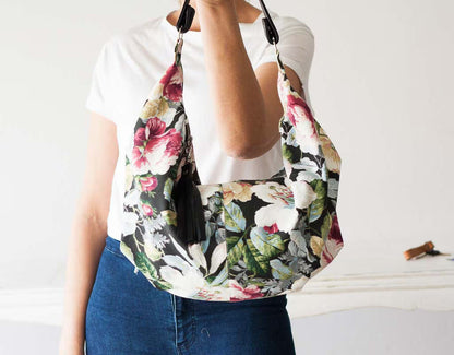 Floral patterned bag worn by a person on a plain background