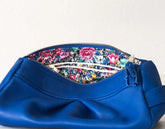 Blue handbag with floral interior on a light gray background