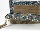 Floral-patterned clutch bag with a brown interior on a white background