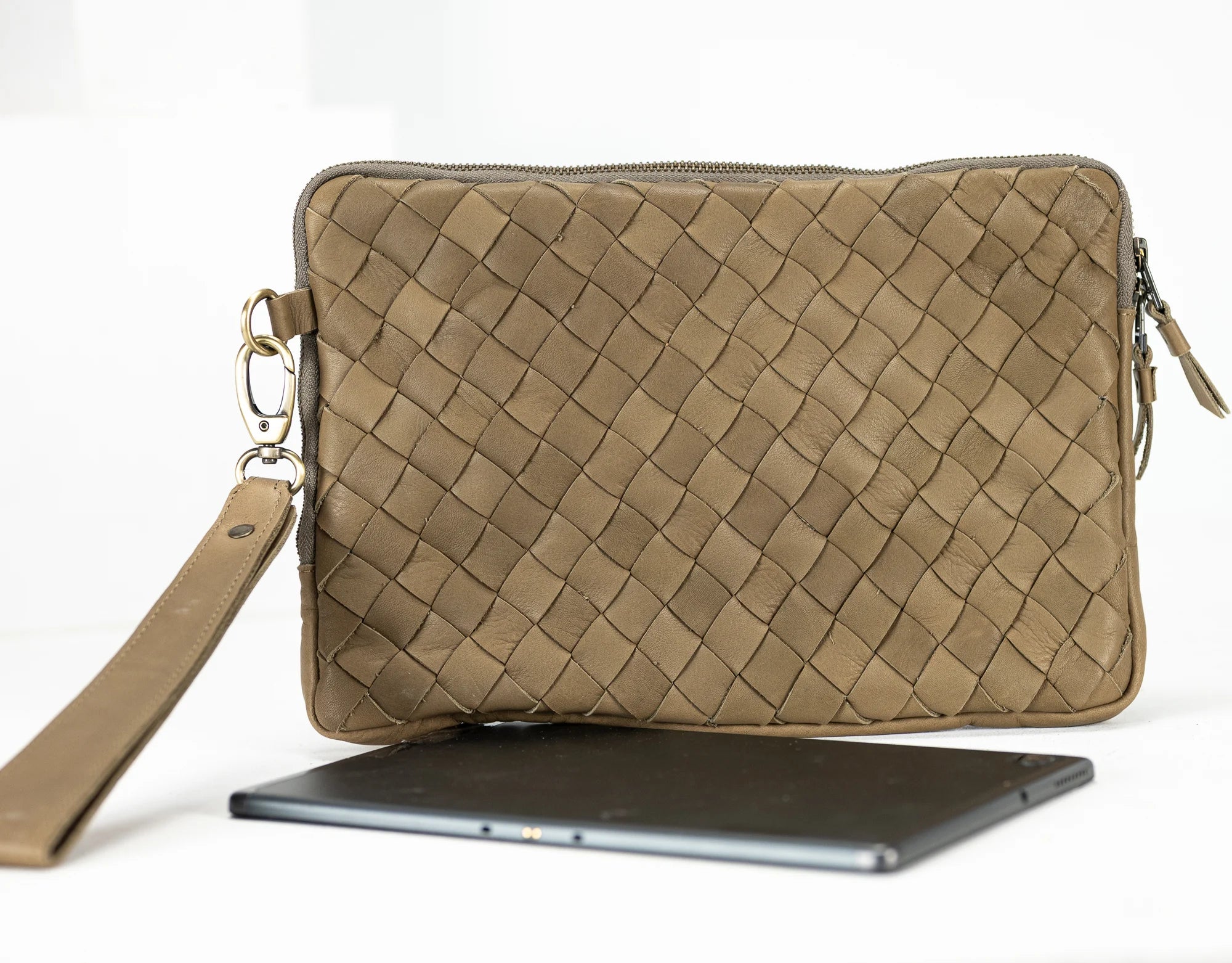 Beige woven clutch bag with a strap on a white background