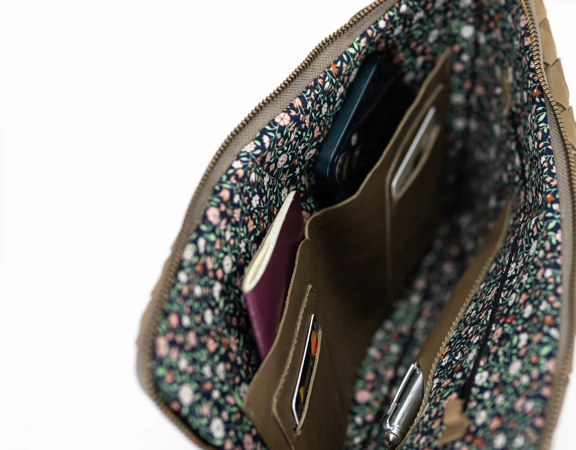 Floral-patterned pouch with a phone and passport inside on a white background