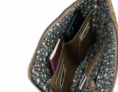 Floral-patterned pouch with a phone and passport inside on a white background