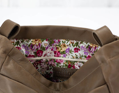 khaki Brown leather bag with floral lining on a white background