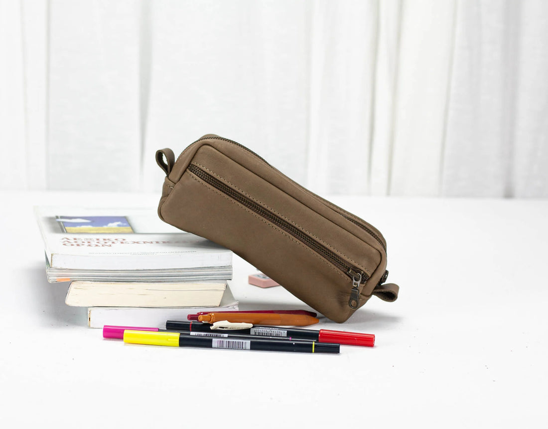 Brown pencil case with stationery items on a white background