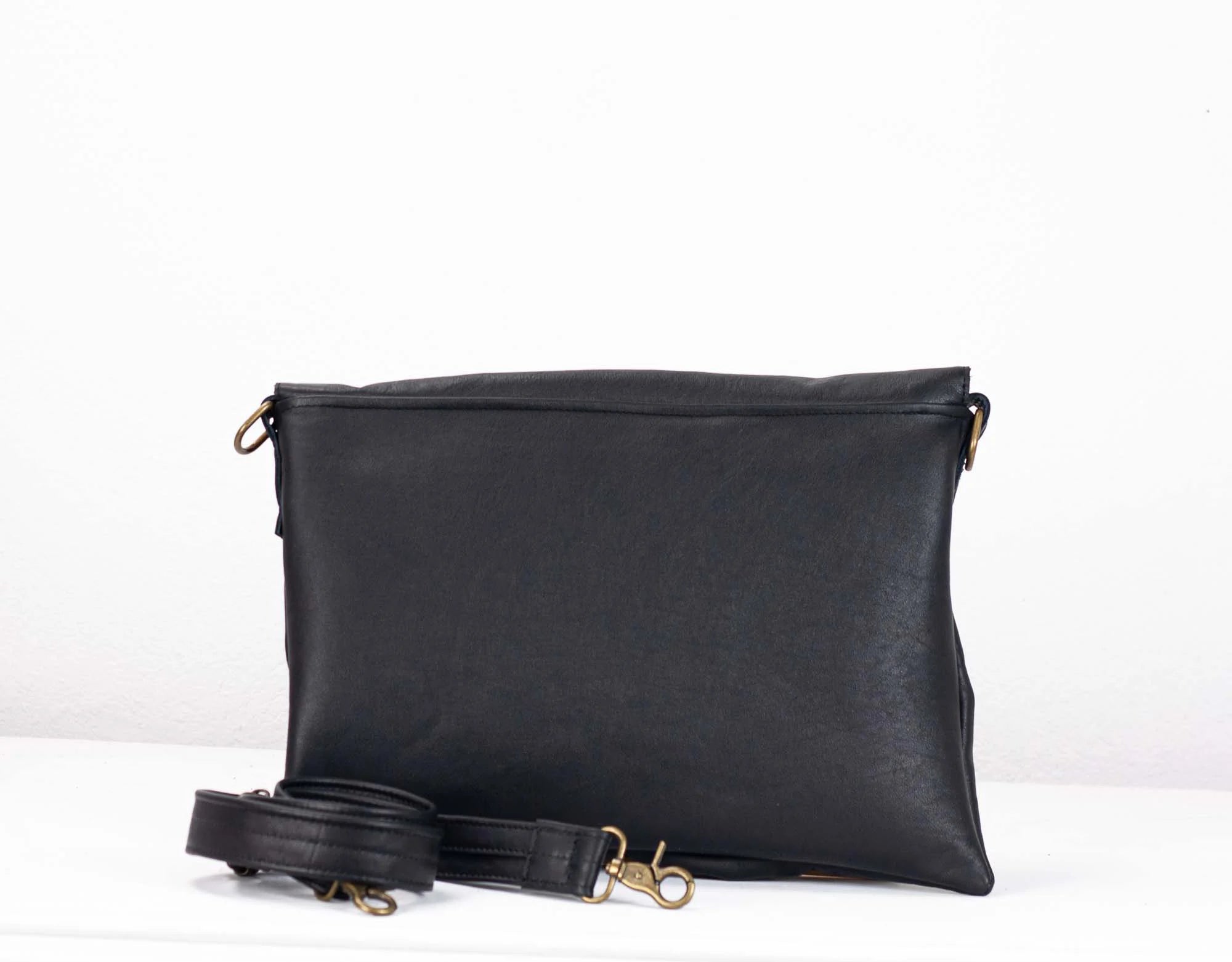 Black leather clutch bag with a strap