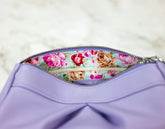 Purple pouch with floral zipper tab on a light background