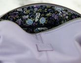 Close-up of a purple garment with floral lining inside a zipper pocket.