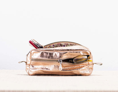 Rose gold pencil case with zipper on a white background