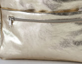 Close-up of a metallic gold bag organizer  with a zipper on a light background
