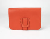 Orange leather wallet with a buckle on a white background