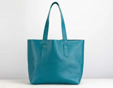 Teal leather tote bag on a white background