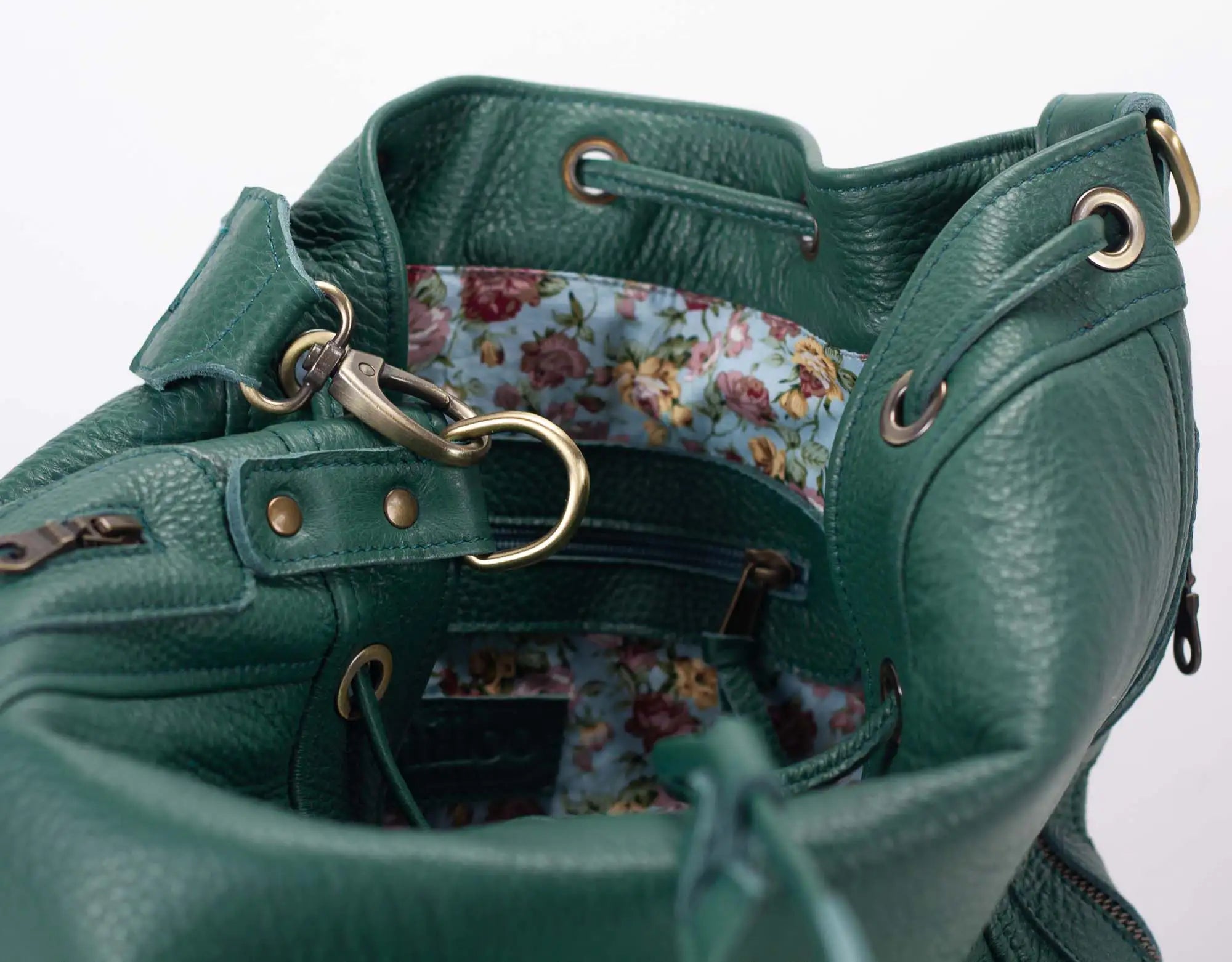 Green leather bag with floral interior on a white background
