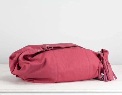 Pink handbag with a tassel on a white background