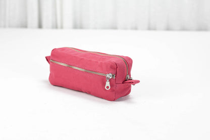 Pink toiletry bag with a silver zipper on a white surface