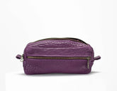 Purple leather dopp kit with gold zipper on a white background