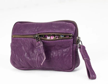 Purple leather clutch bag with a wrist strap on a white background