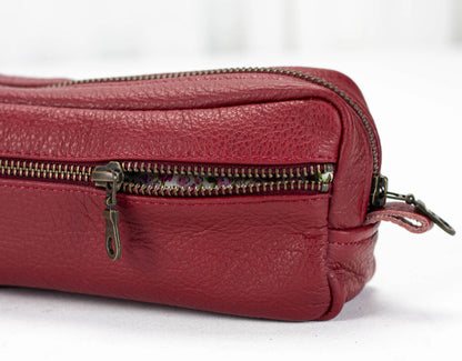 Red leather bag with multiple zippers on a white background