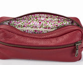 Red leather pouch with floral interior on a white background