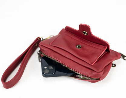 Red leather crossbody bag with a phone inside on a white background