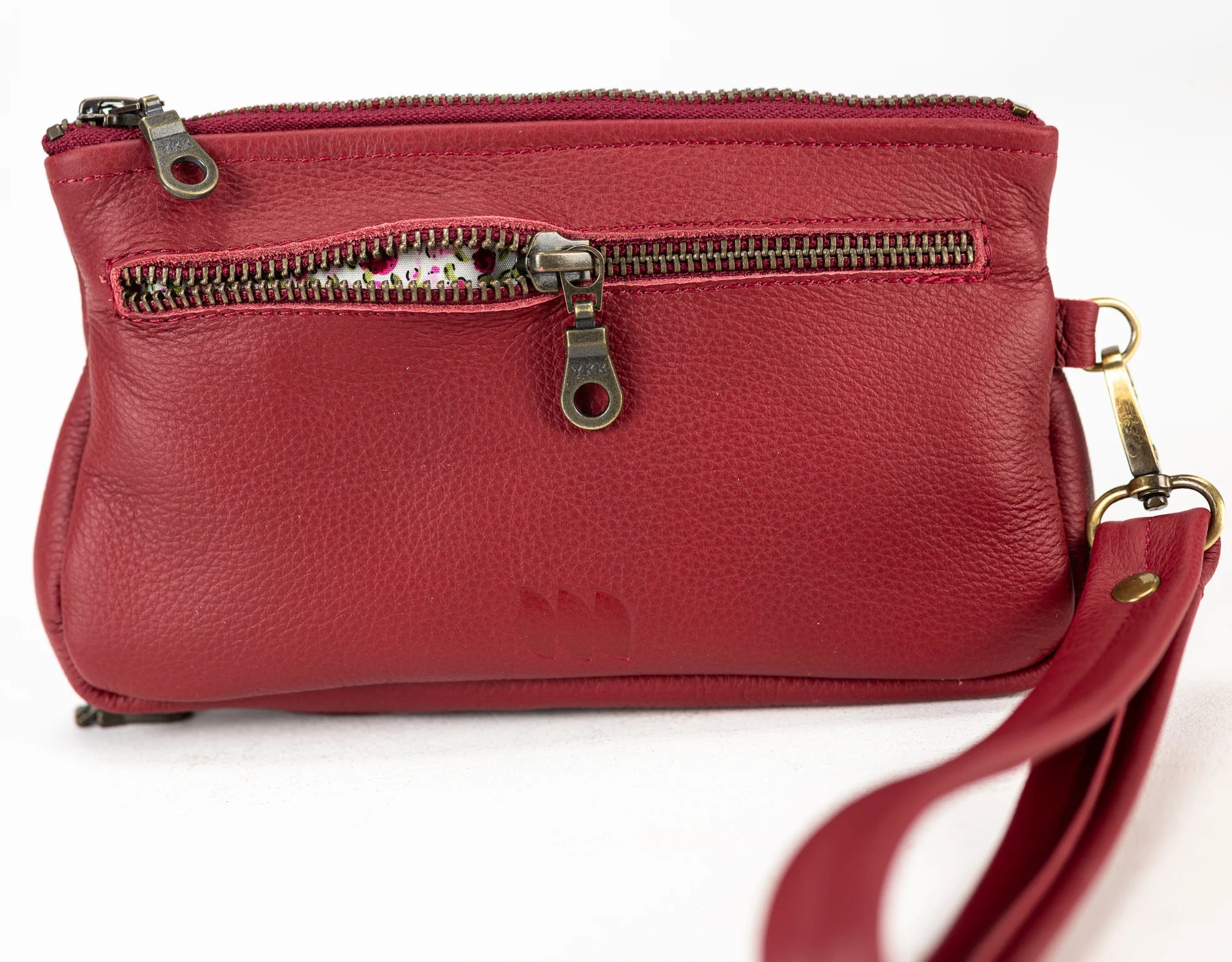 Red leather handbag with a strap on a white background