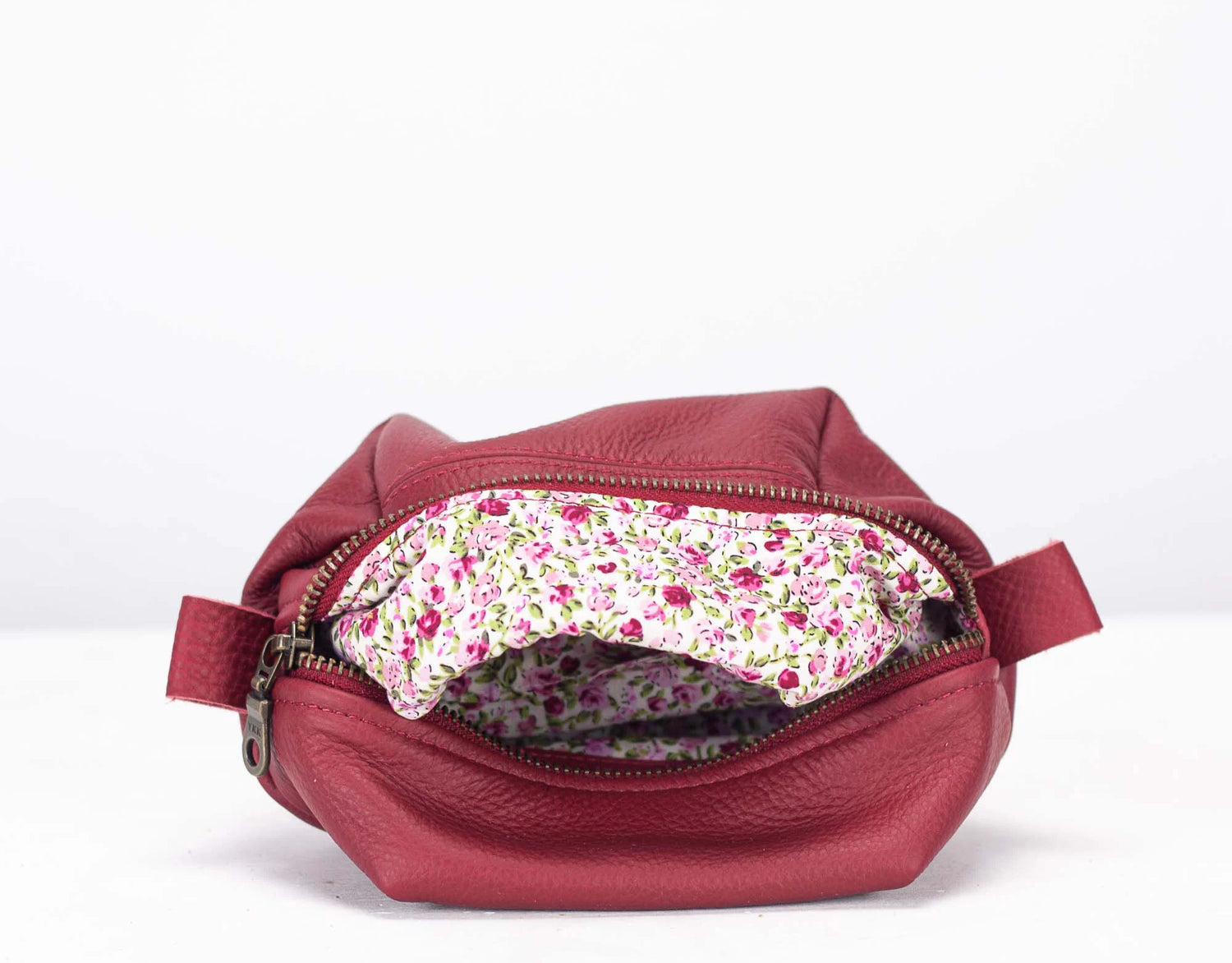 Red leather bag with floral interior on a white background