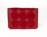 Red leather clutch with geometric pattern on a white background