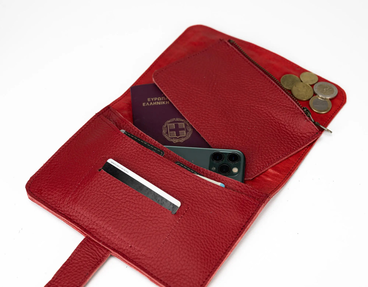 Red leather wallet with various items including a phone, coins, and a passport.